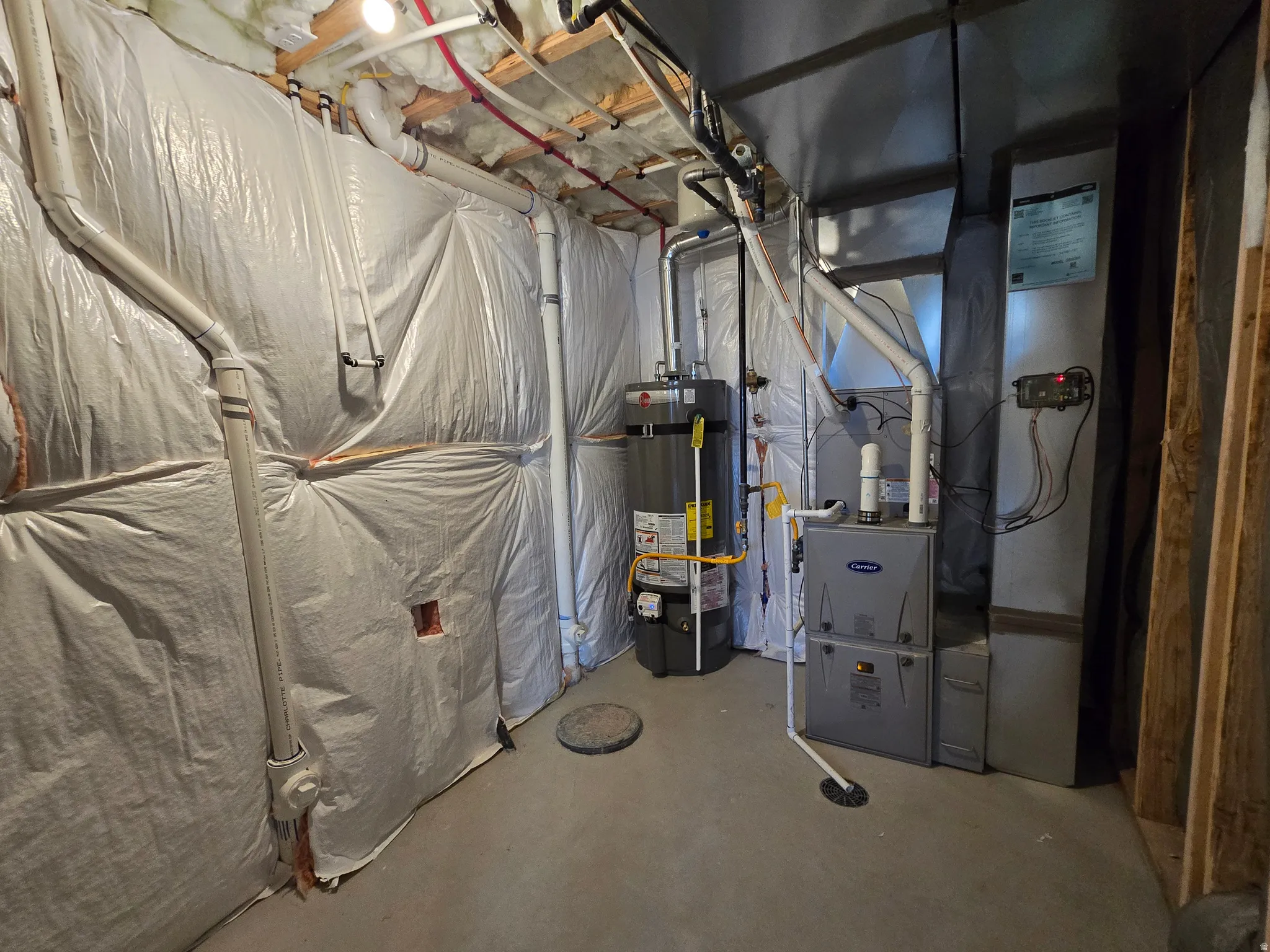 Utility space featuring a water heater, furnace, and exposed piping