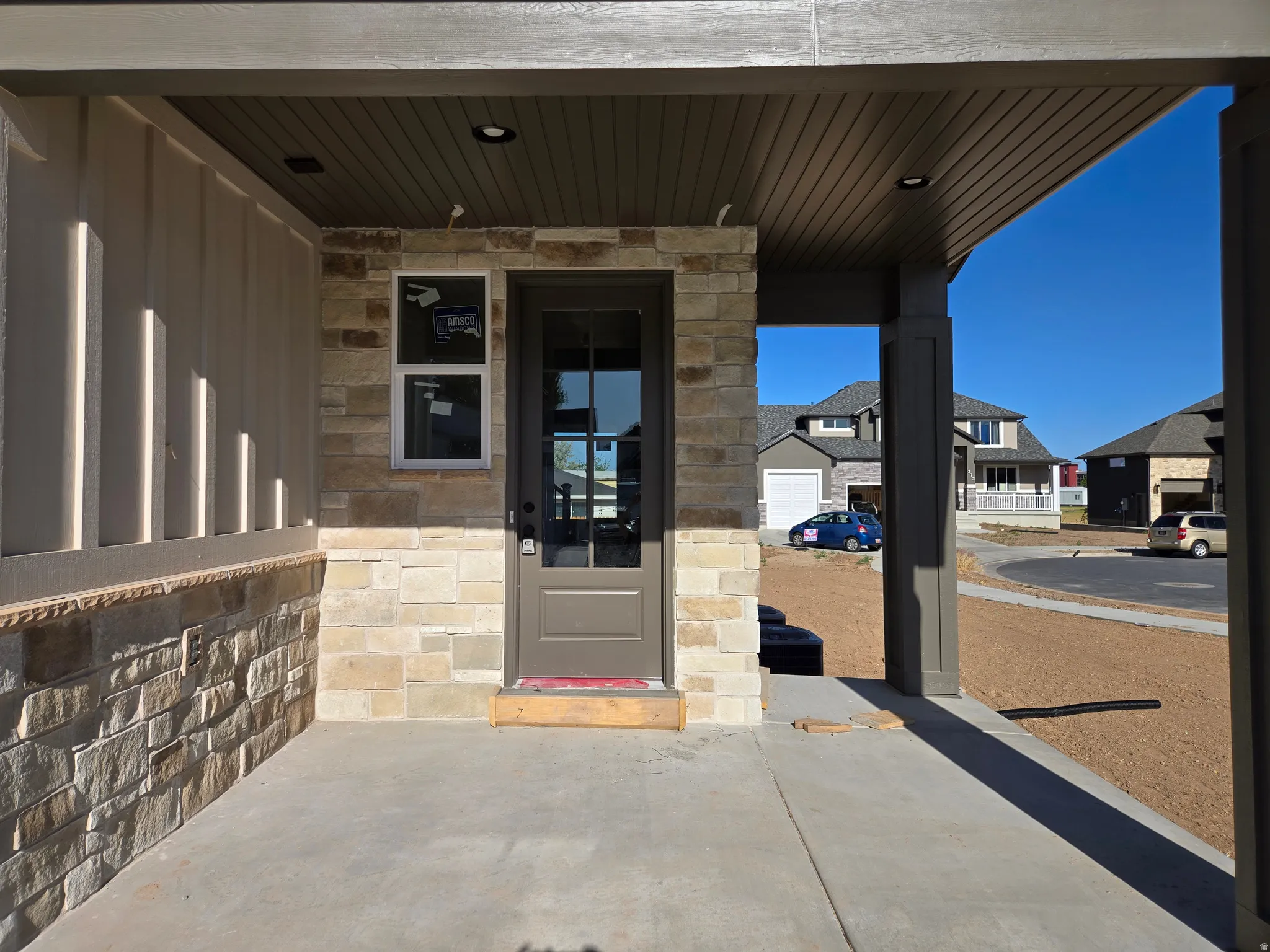 Covered porch entry featuring stone veneer and vertical siding accents