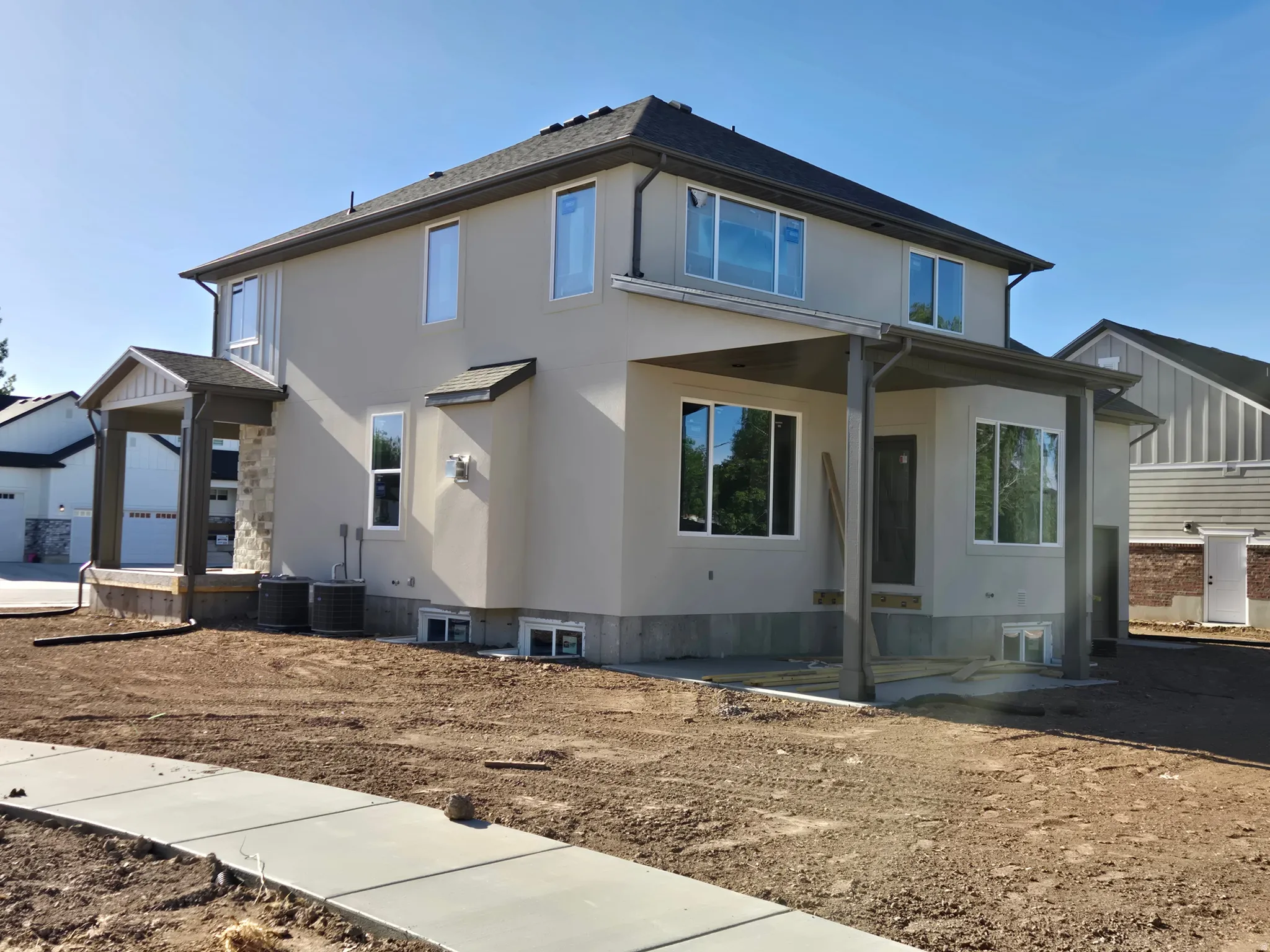 Two-story stucco residence featuring a covered front porch with stone accents
