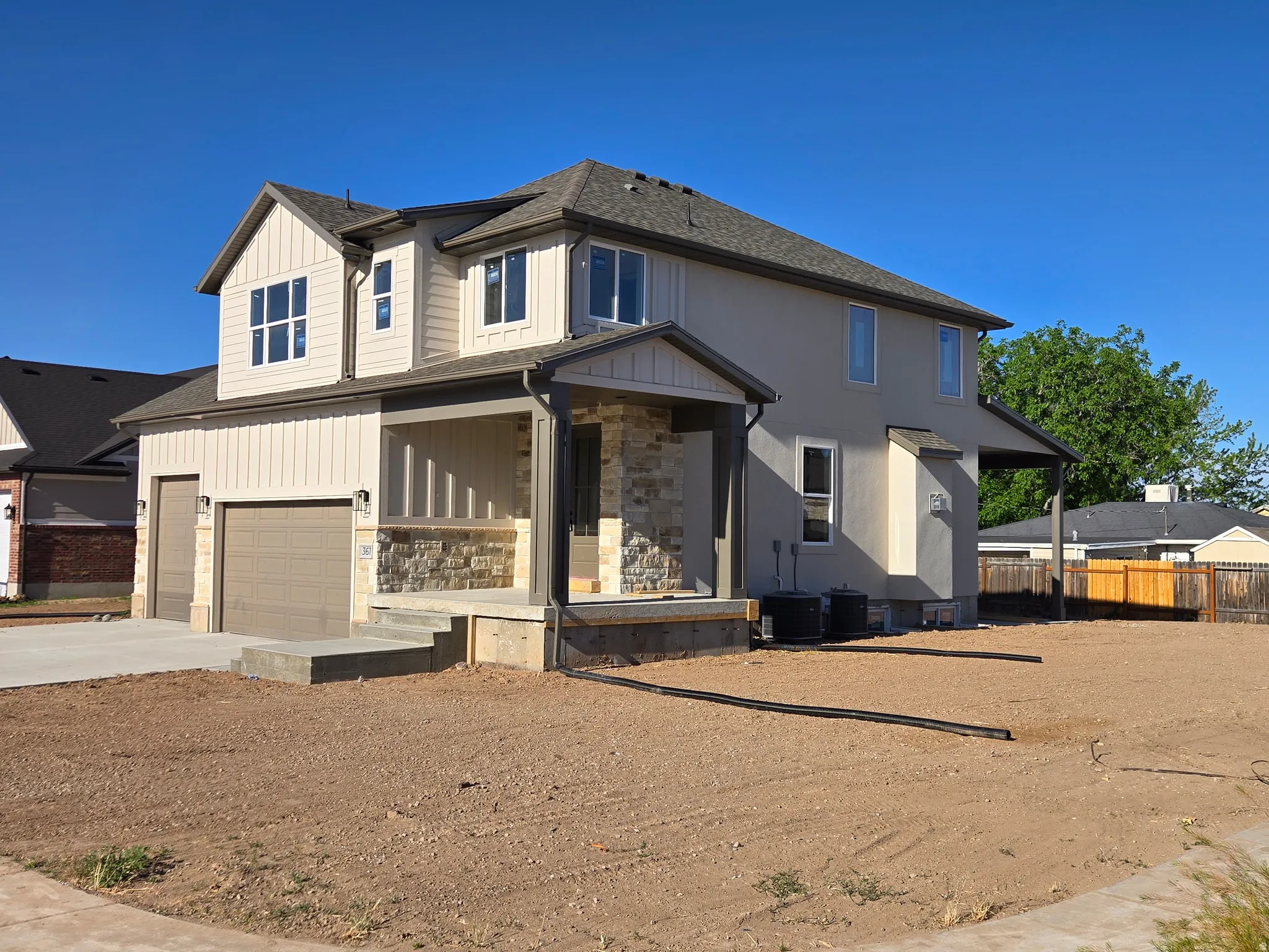 Contemporary two-story residence featuring a combination of horizontal siding, vertical board and batten accents, and stone veneer