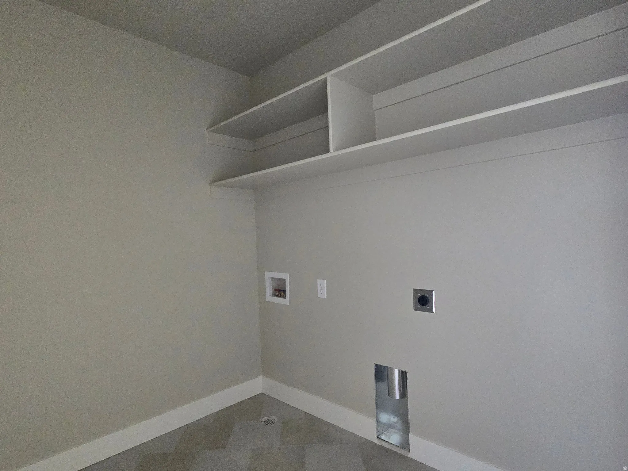 Utility room featuring built-in shelving, tile flooring, and appliance hookups