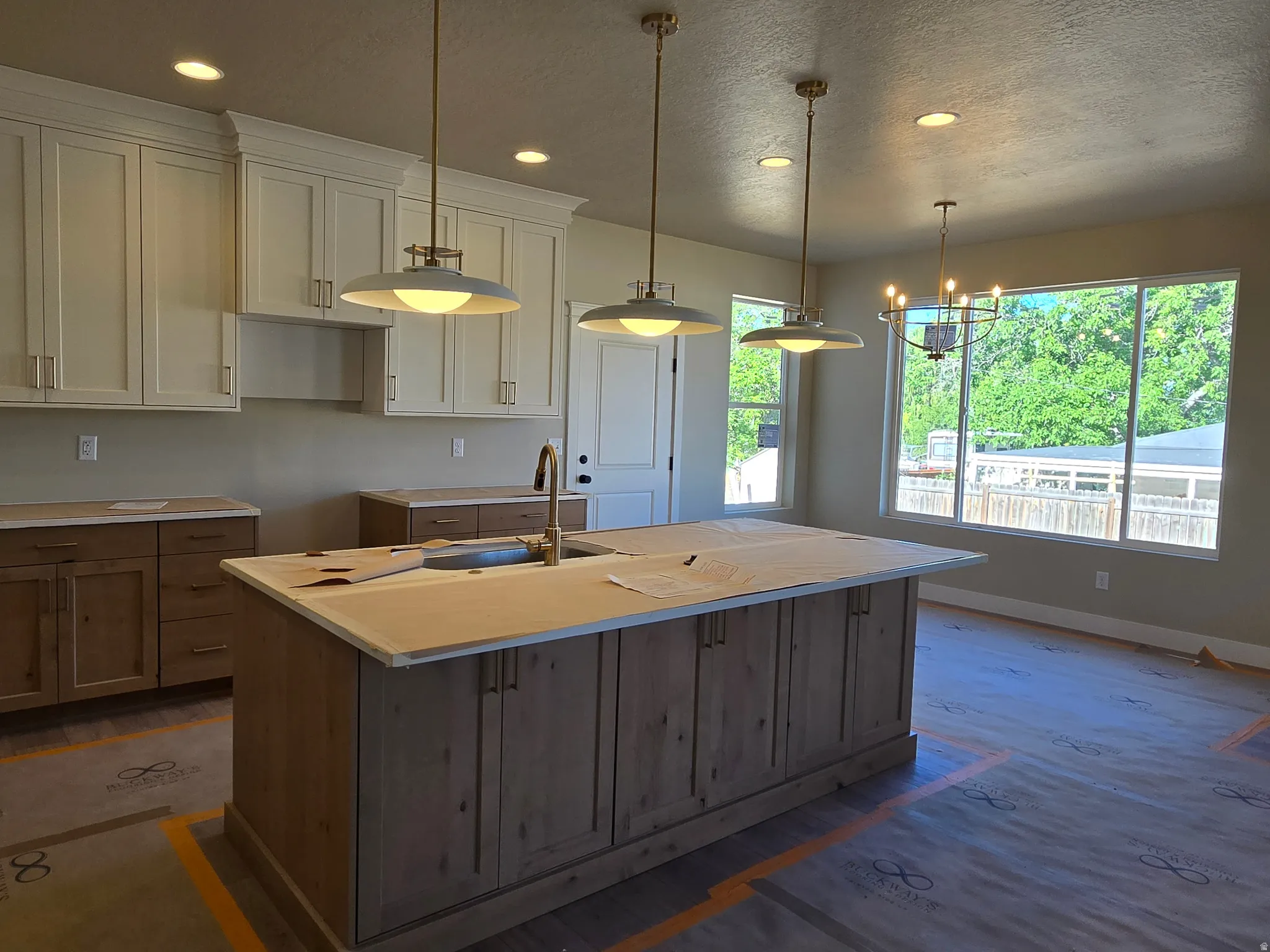 Spacious kitchen featuring a large central island with integrated sink and brass faucet