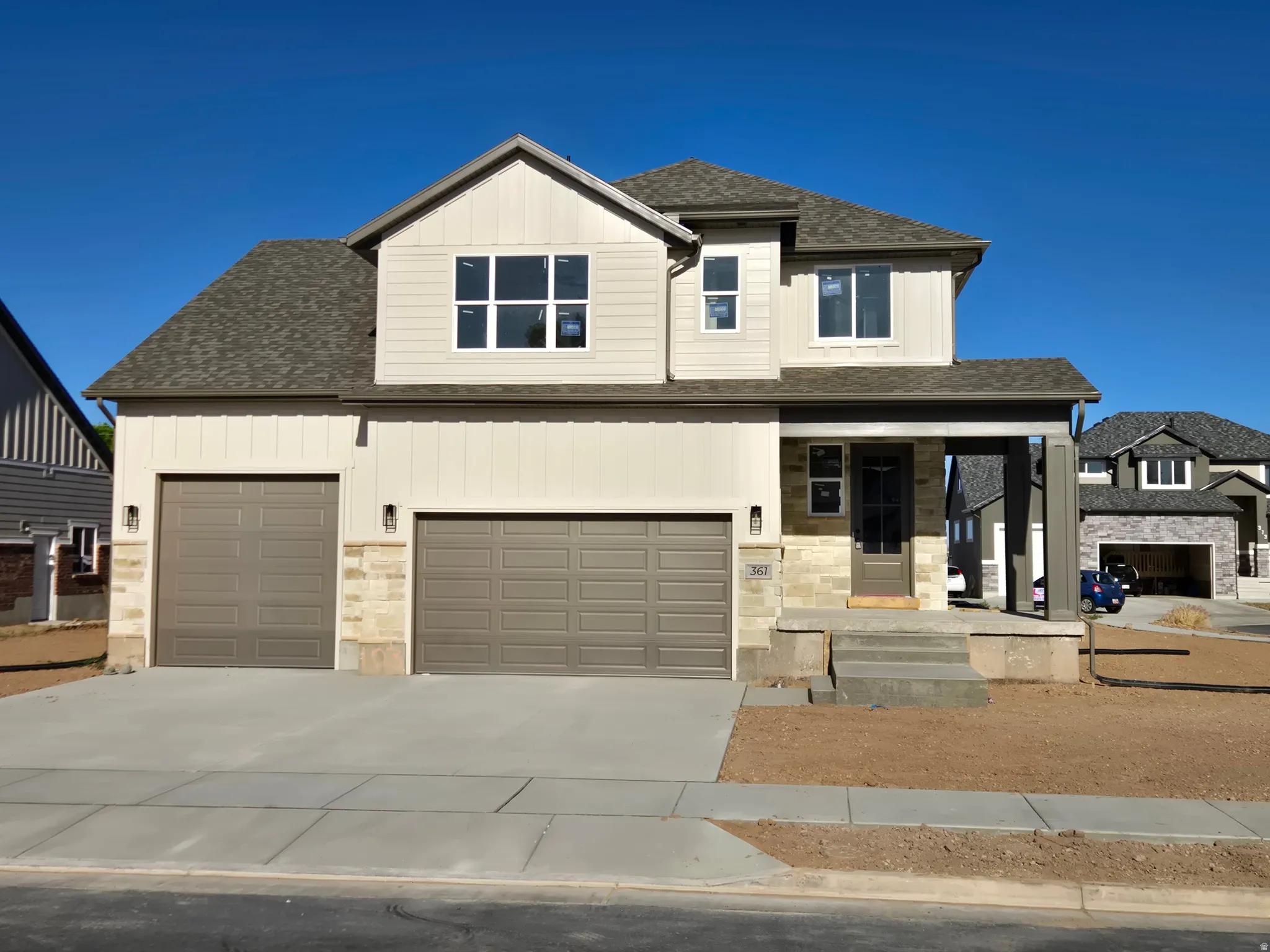 Contemporary two-story residence featuring a neutral exterior with board and batten siding and stone accents