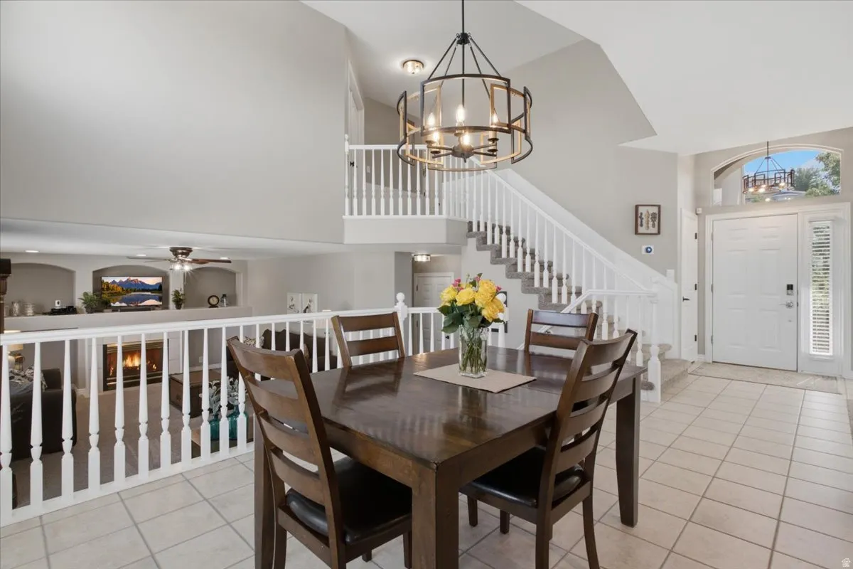 Entryway featuring a double door with an arched transom, a wrought iron chandelier, and a staircase with white balusters