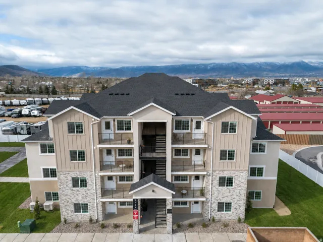 Multi-story facade featuring stone veneer accents and vertical siding