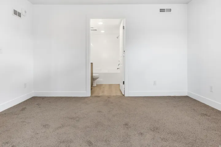 Carpeted flooring in the main room complemented by white baseboards
