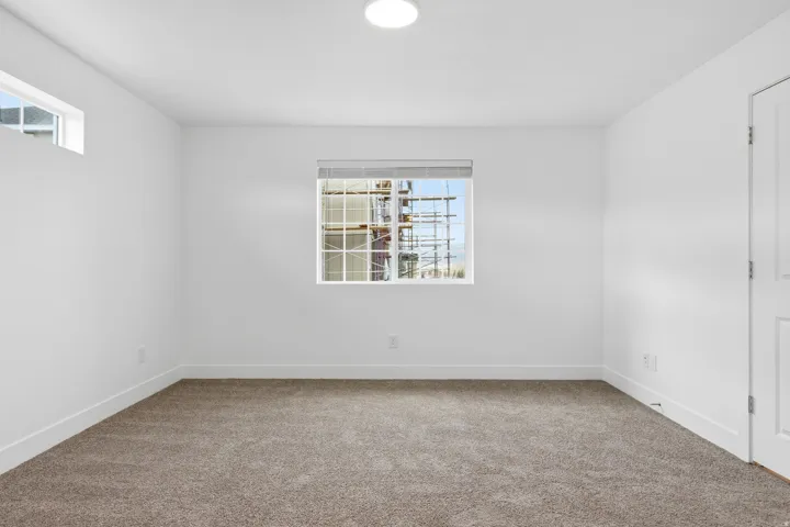 Room featuring plush brown carpet, white walls, and white trim