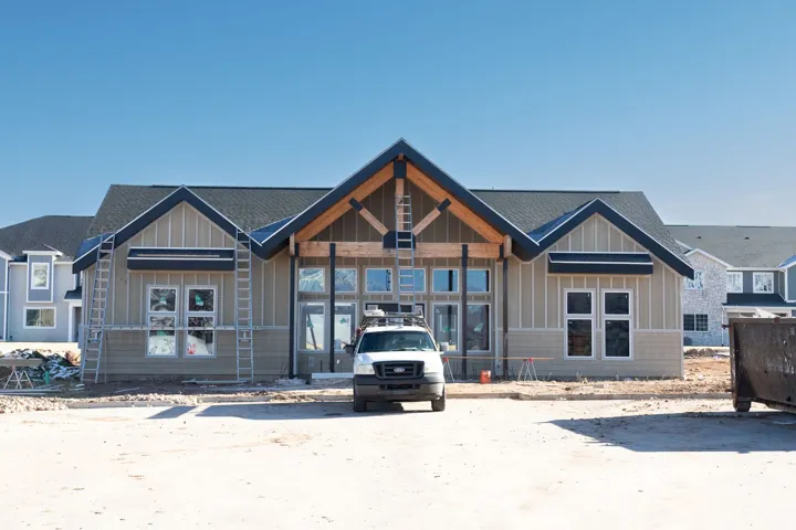 Newly constructed exterior featuring board and batten siding, horizontal siding, dark shingle roofing, and exposed wood beam accents