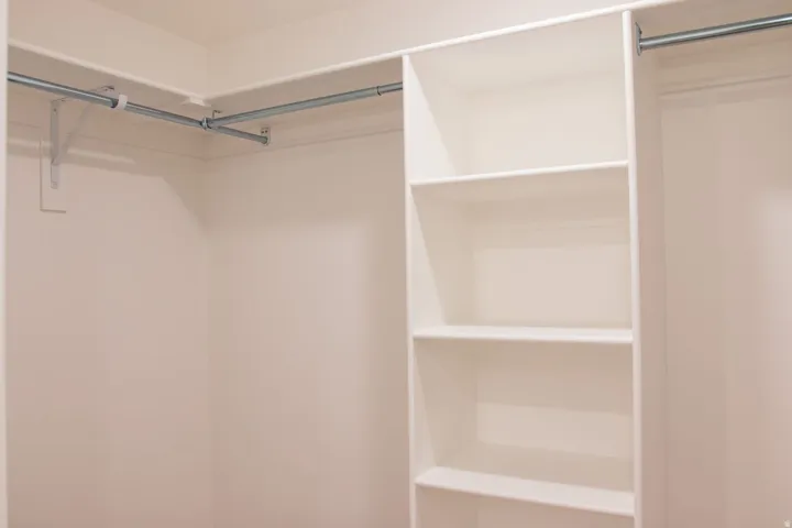 Integrated closet system featuring multiple hanging rods and built-in shelving