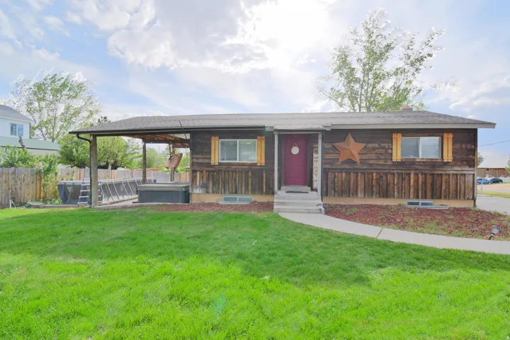 Ranch-style exterior with wood siding, a covered patio, and a fenced backyard