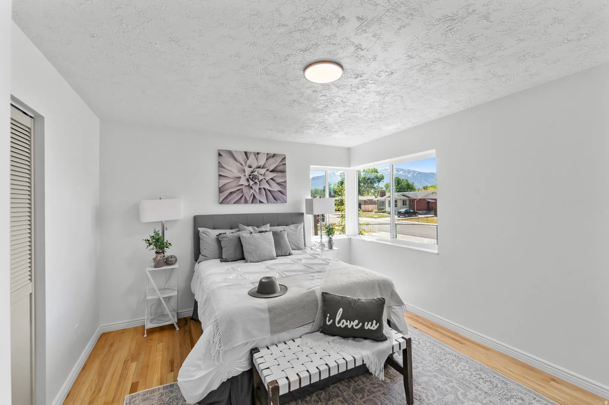 Bright interior space featuring light wood-finish flooring, white walls, and a textured ceiling