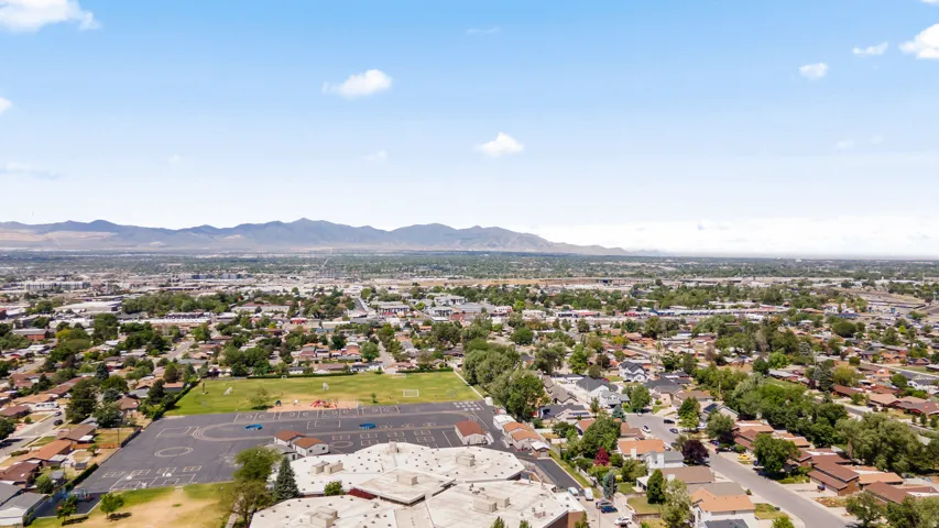 Expansive aerial perspective showcasing a residential neighborhood with distant mountain ranges