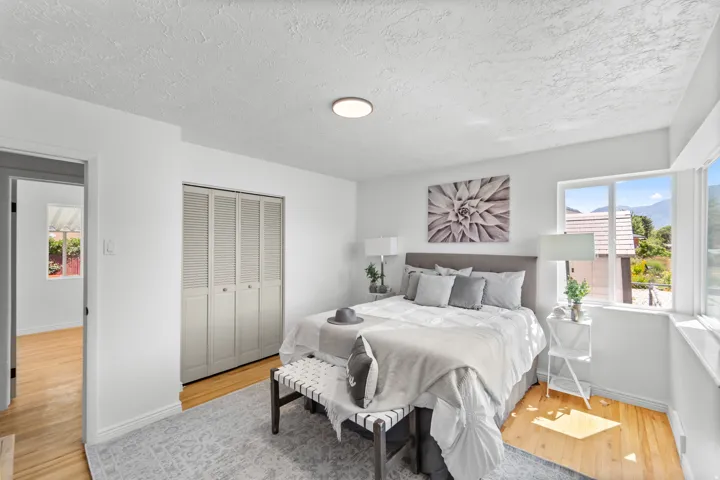 Neutral-toned room featuring light wood-finish flooring and a bi-fold closet