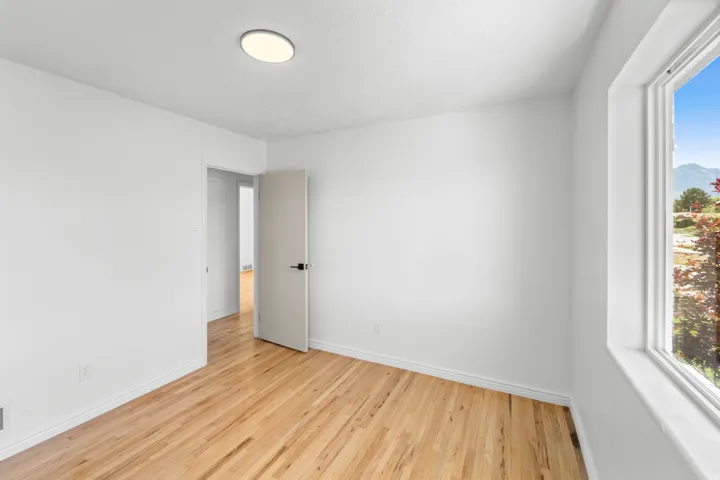 Bright interior space featuring wood-finish flooring, white walls, and a recessed ceiling light fixture