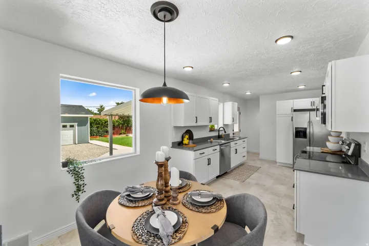 Kitchen featuring white cabinetry, dark countertops, stainless steel appliances, and recessed lighting