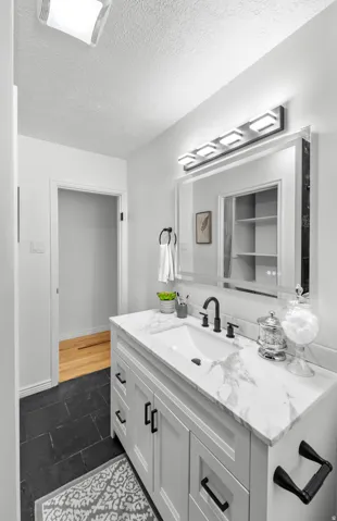 Bathroom vanity with a white marble-look countertop, integrated rectangular sink, and matte black faucet