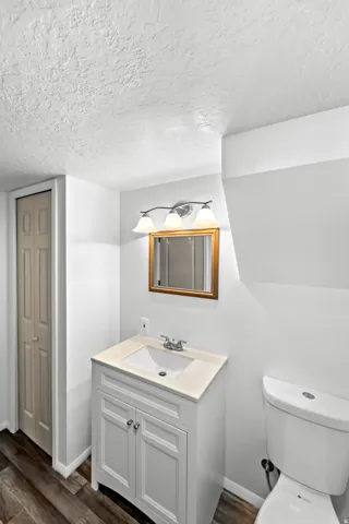 Bathroom vanity with a light countertop, integrated sink, and brushed nickel faucet
