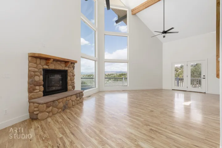 Spacious room featuring soaring vaulted ceilings with an exposed wood beam and multiple large windows