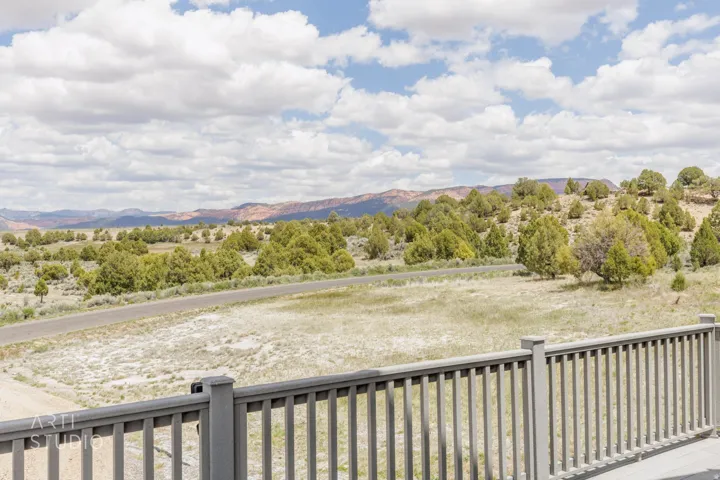 Expansive outdoor scenery featuring mature trees and distant red rock formations