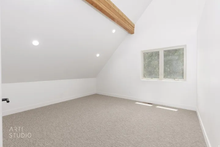Carpeted room featuring a cathedral ceiling, exposed wood beam, recessed lighting, and a double window