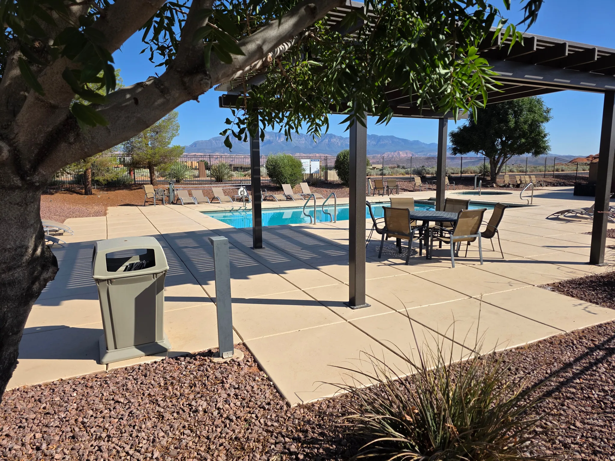 Outdoor pool area featuring a built-in spa, a metal pergola, and concrete paver decking