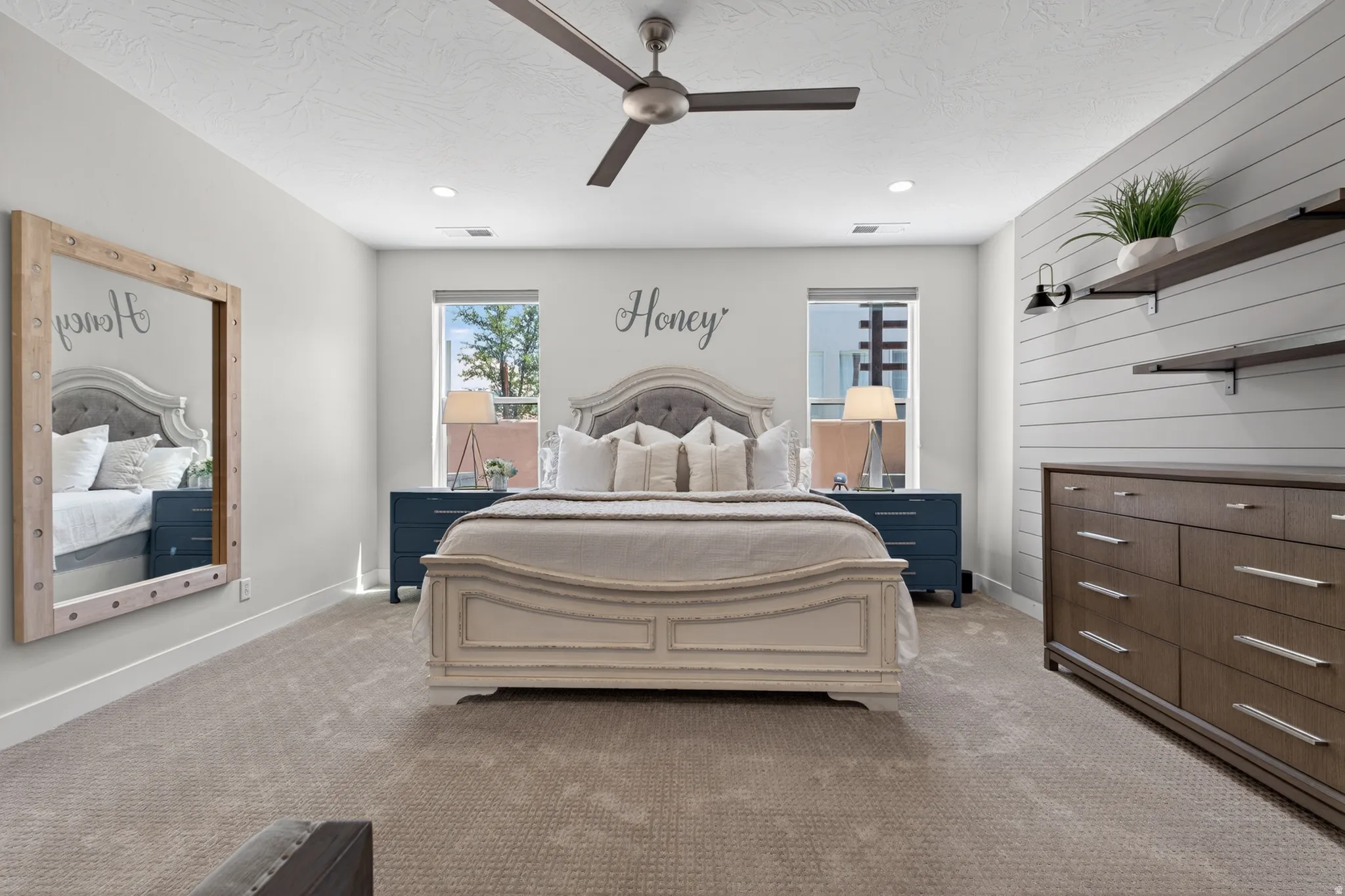 Carpeted bedroom featuring a ceiling fan with integrated lighting, recessed lighting, and dual windows