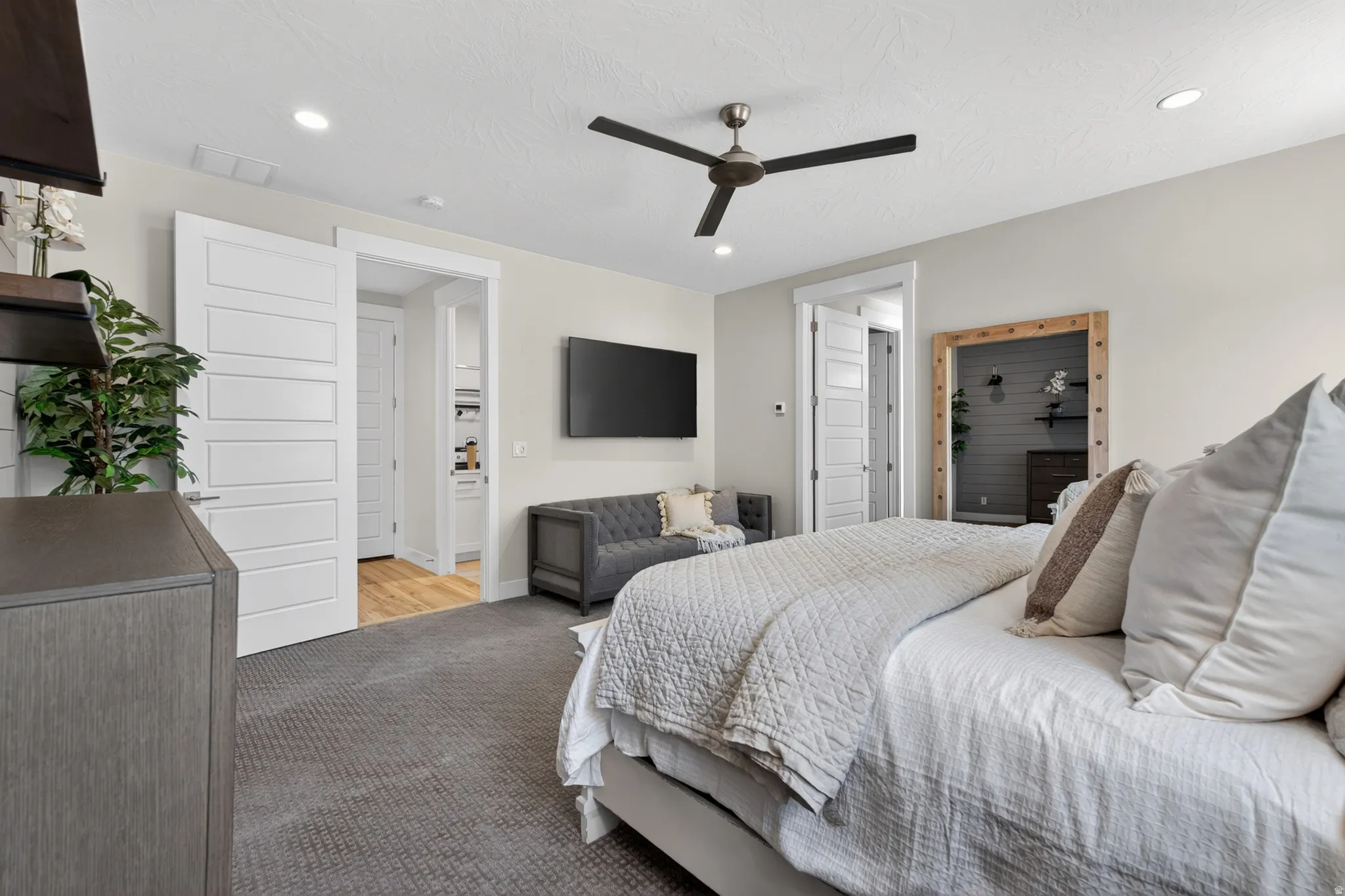 Spacious room featuring neutral carpeting, a contemporary ceiling fan, recessed lighting, and modern paneled doors