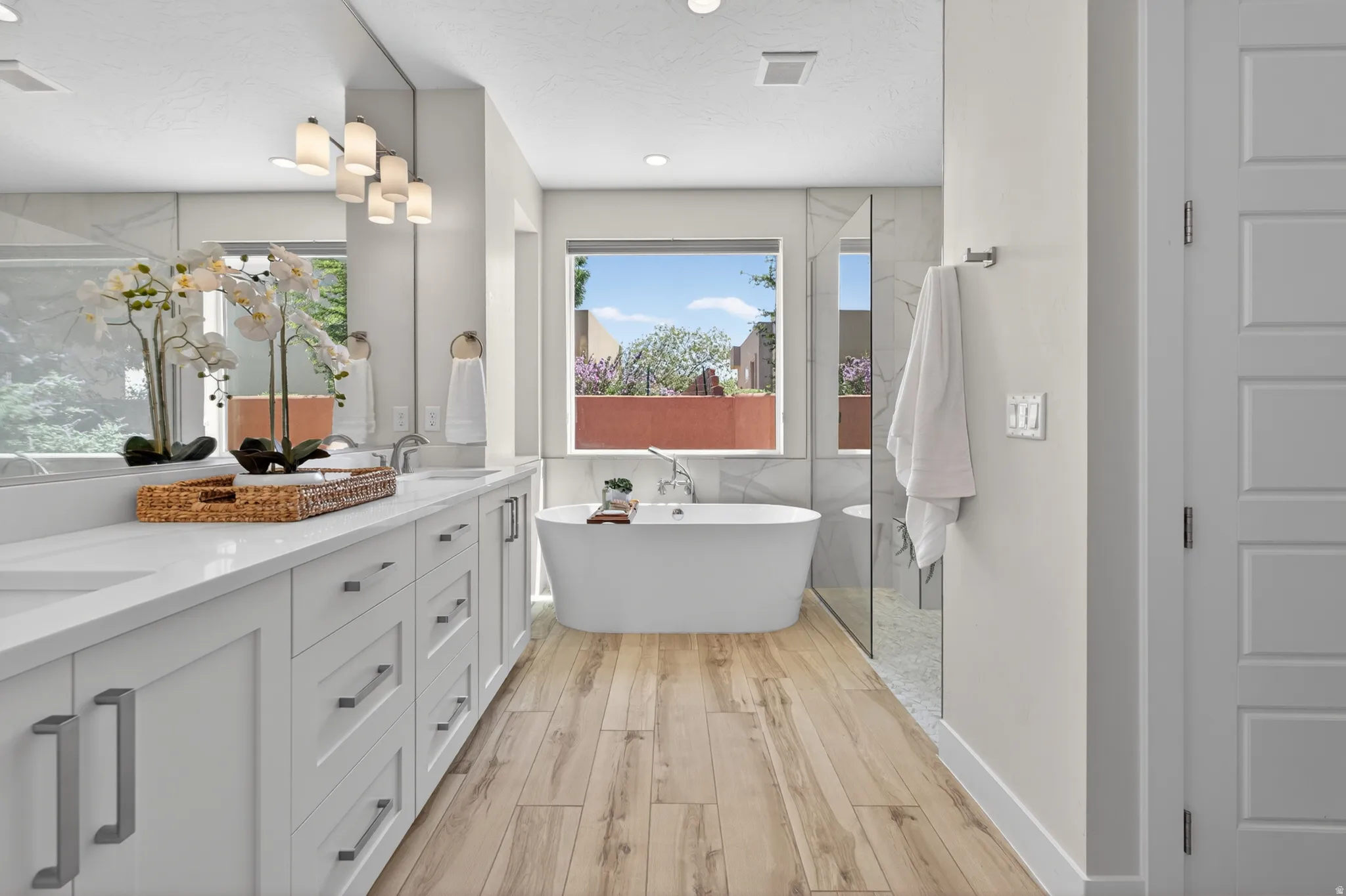 White freestanding bathtub positioned under a window