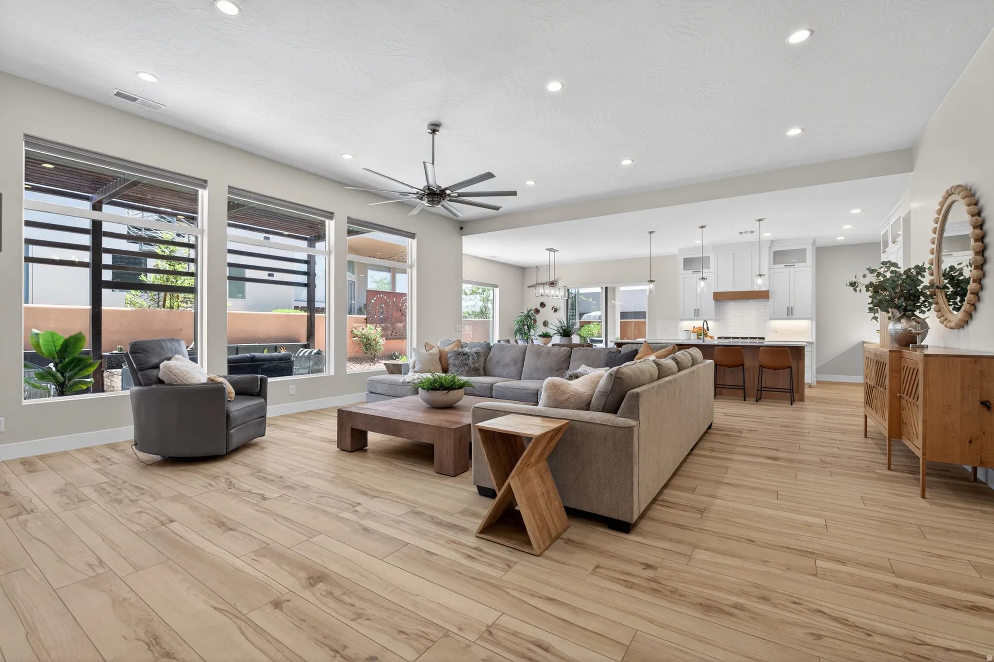 Open-concept living space featuring wood-finish flooring, recessed lighting, and a contemporary ceiling fan