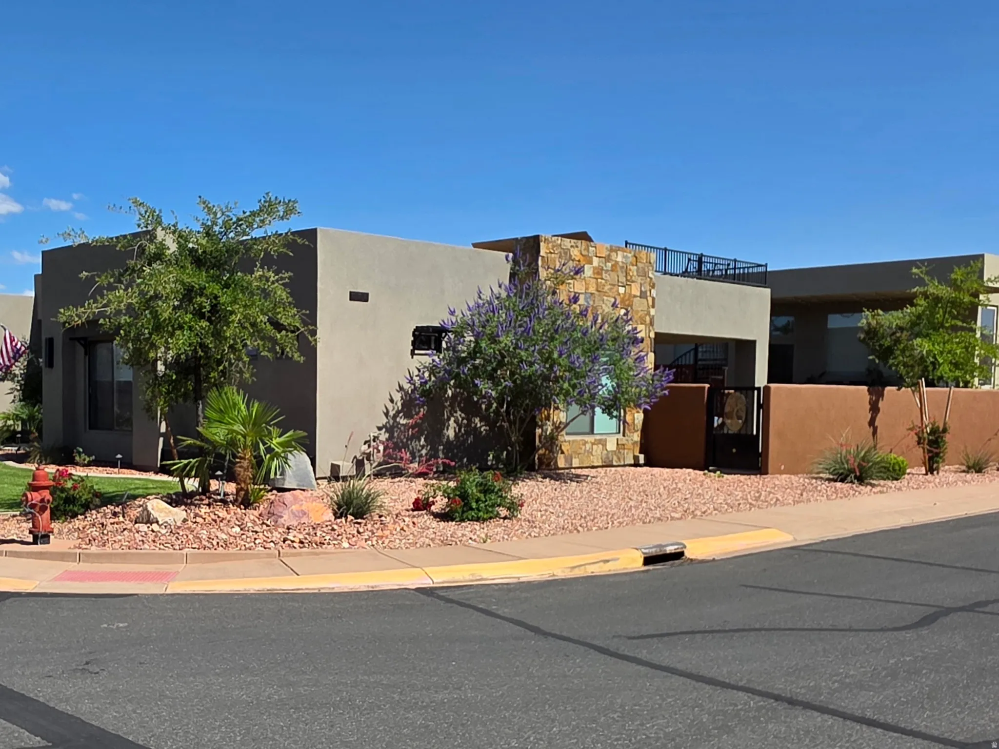 Modern desert-style residence with a stucco exterior, stone facade accents, and a flat roofline