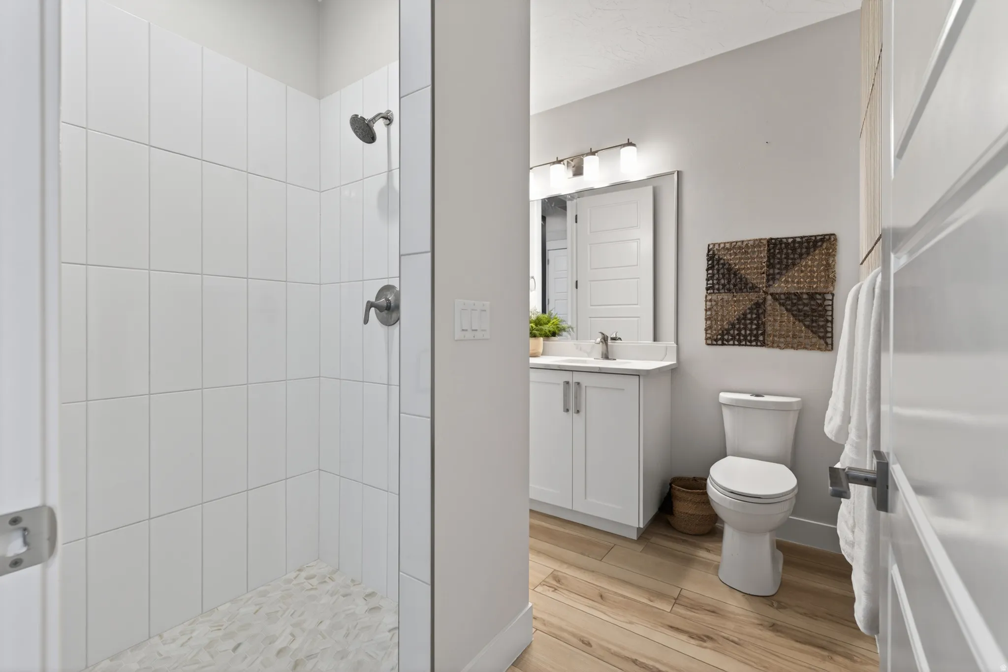 Tiled shower with pebble-finish flooring and brushed nickel fixtures