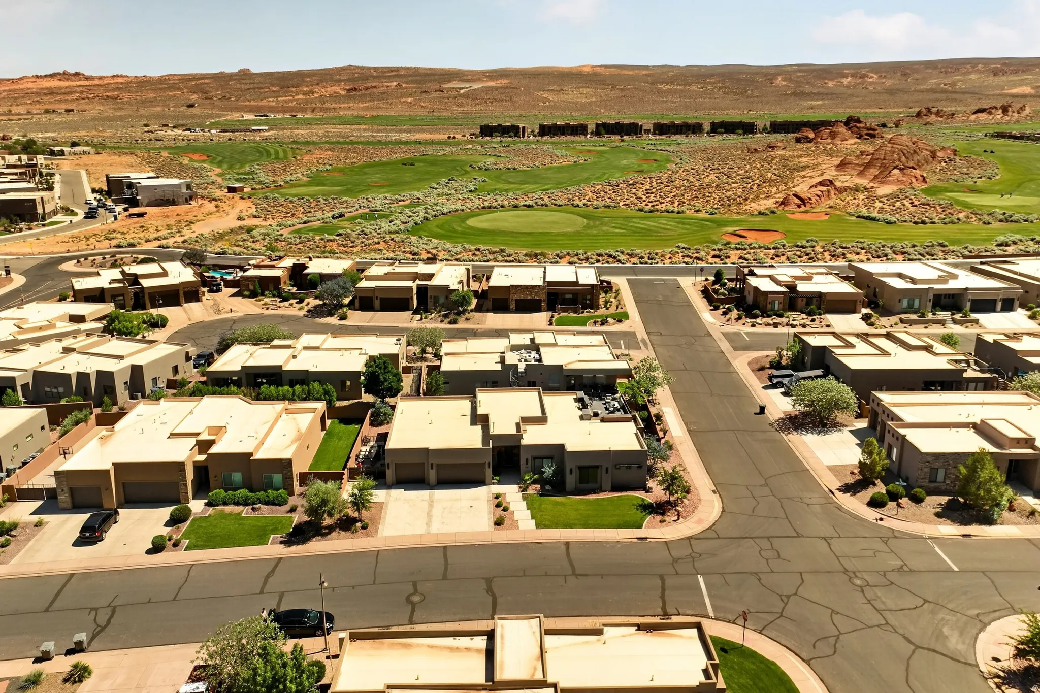 Desert landscape community featuring single-story residences, paved streets, and a golf course