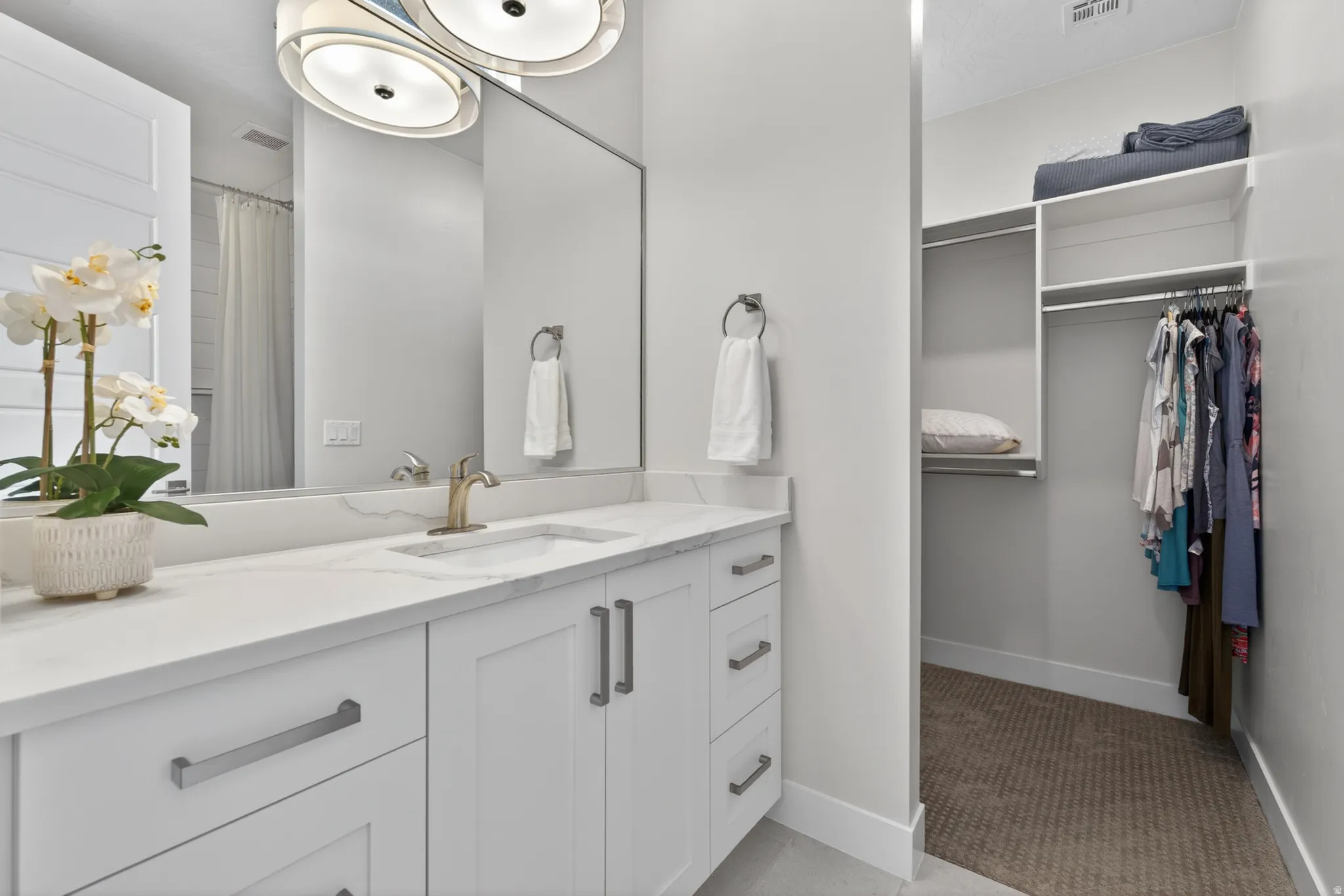 Bathroom vanity featuring a single integrated sink, brass-finish faucet, and white countertop