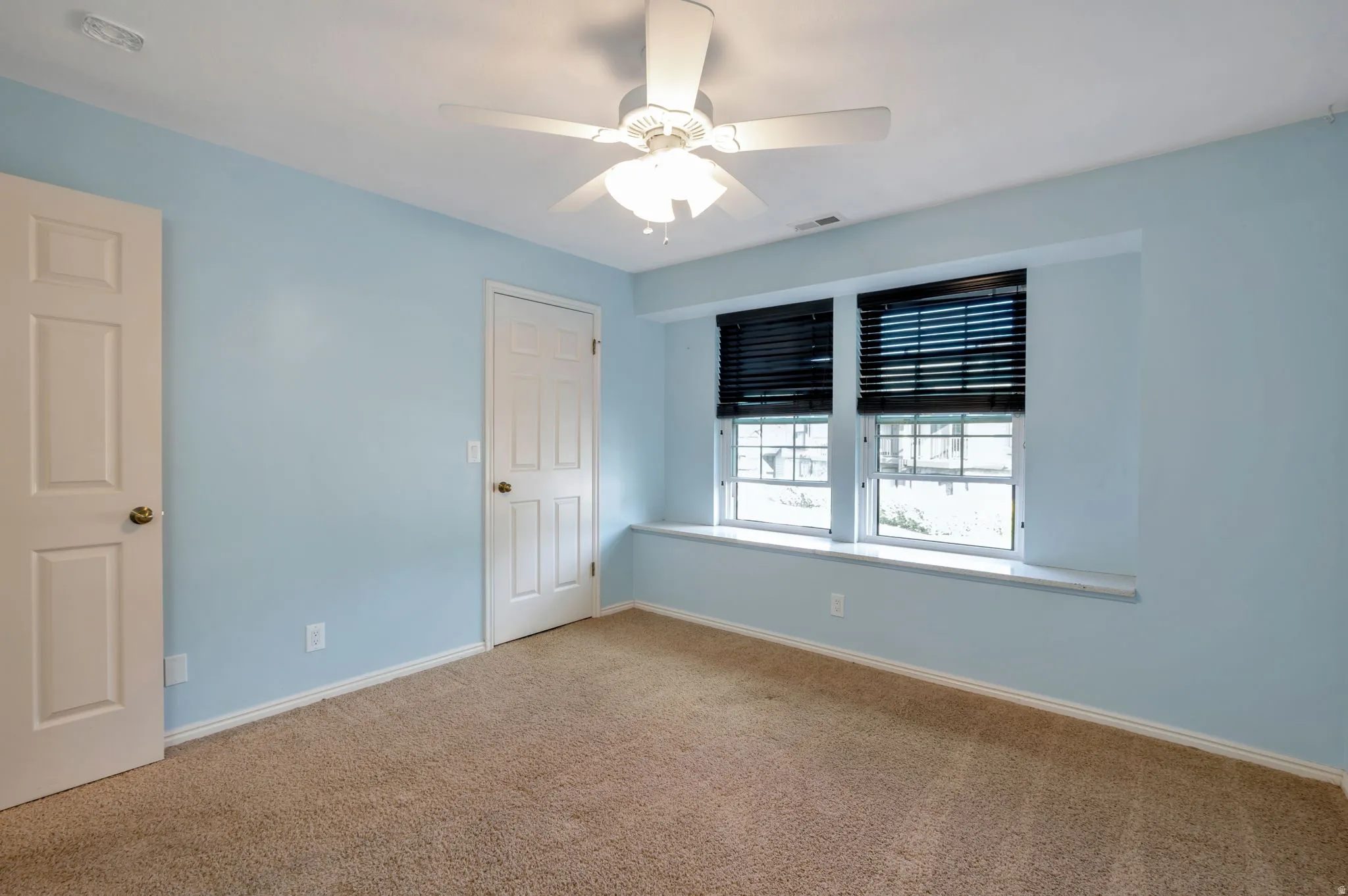 Carpeted room with light blue walls and white trim
