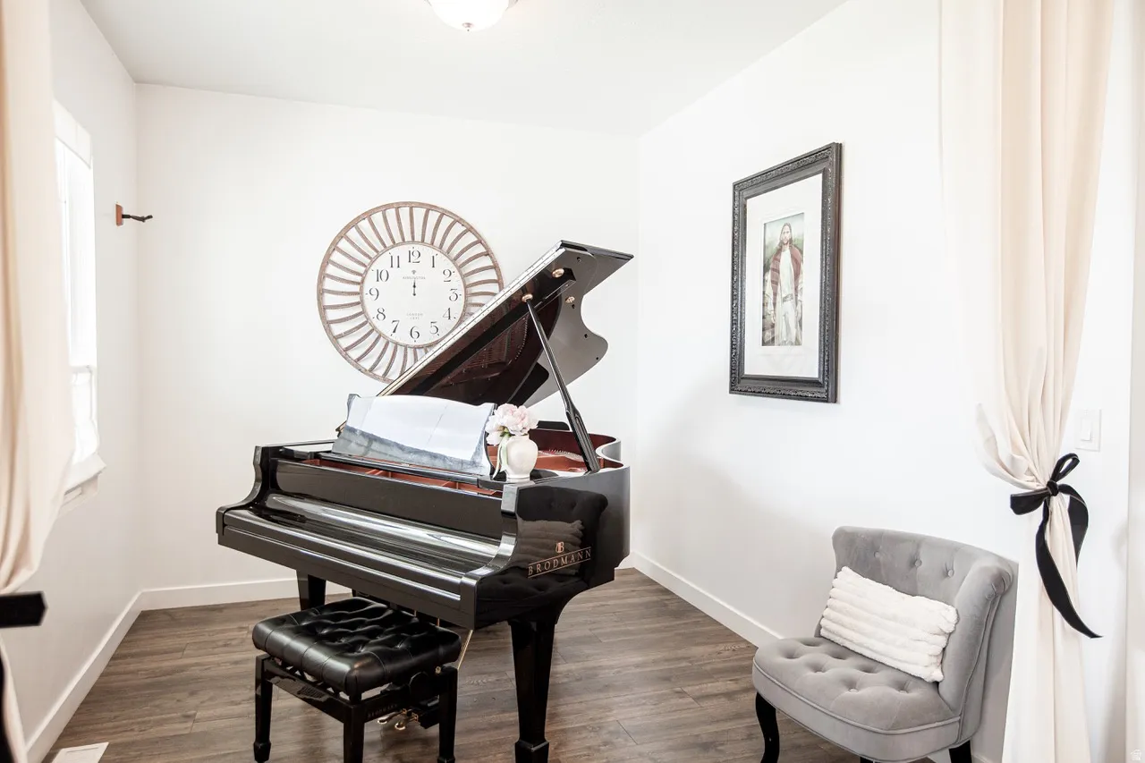 Room featuring wood-finish flooring, white walls, and a ceiling-mounted light fixture