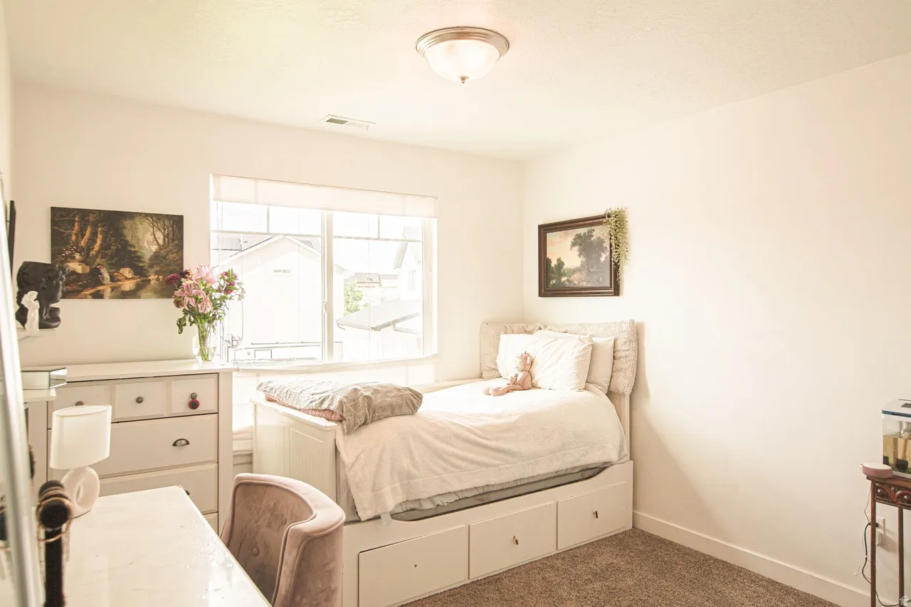 Bright room featuring a large window, neutral wall paint, and a built-in bed frame with integrated storage drawers