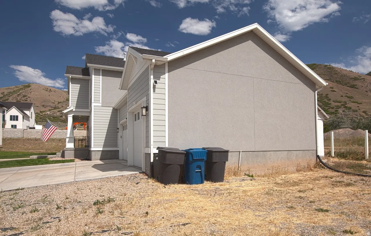 Contemporary exterior featuring light gray stucco and siding, white trim, and a concrete driveway