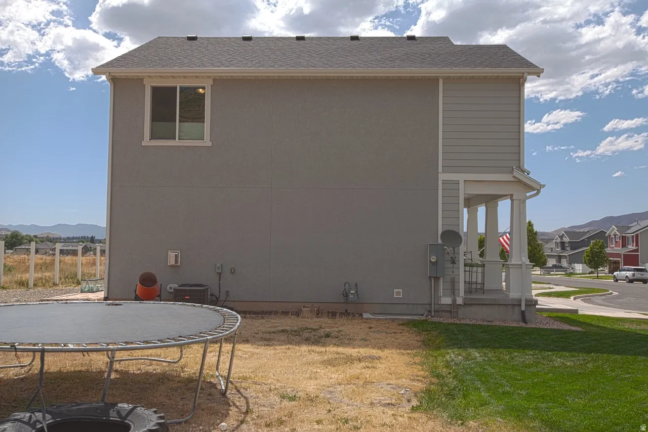 Two-story residence featuring a gray exterior with contrasting light gray horizontal siding and a covered entry porch supported by white columns