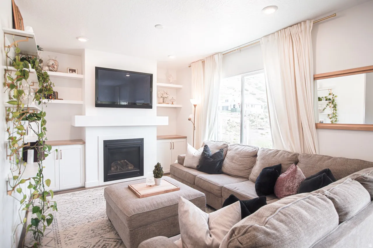 Living area featuring a built-in fireplace with a mantel, integrated shelving, and lower cabinetry with wood-finish countertops