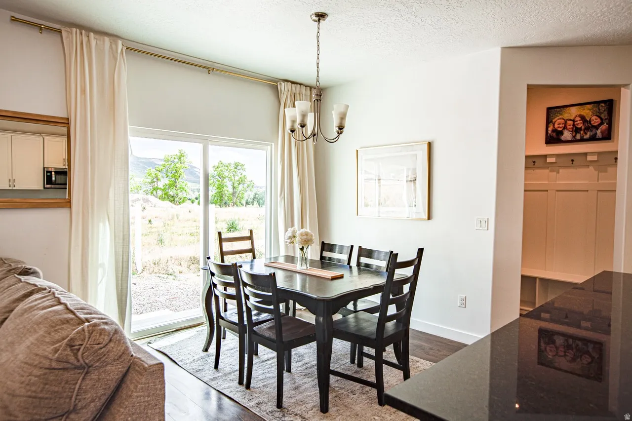 Dining area with wood-finish flooring and a pendant light fixture