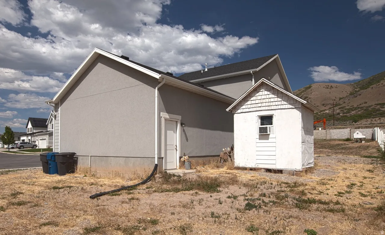 Light gray stucco exterior with white trim