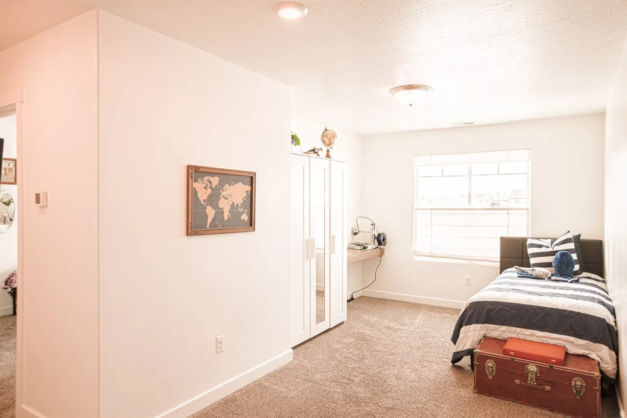 Carpeted room featuring a window with horizontal blinds, a built-in desk, and a recessed ceiling light