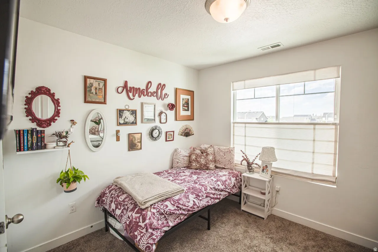 Recessed lighting fixture, window with horizontal blinds, neutral wall paint, and gray carpeted flooring