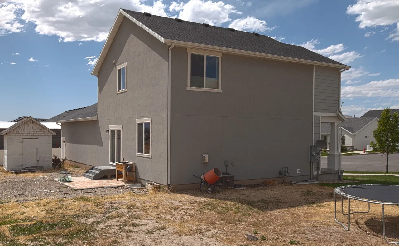 Contemporary stucco exterior with a dark shingle roof