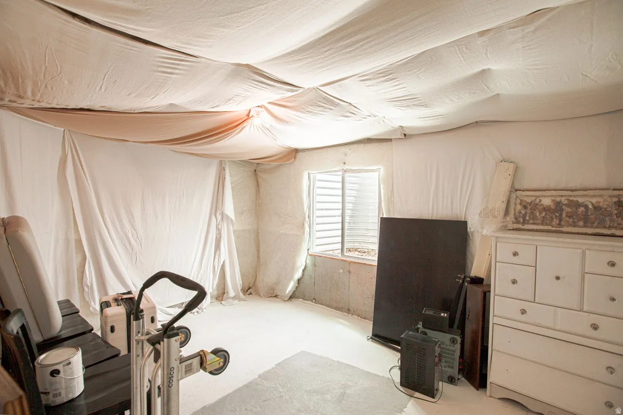 Basement space featuring a window opening and concrete walls