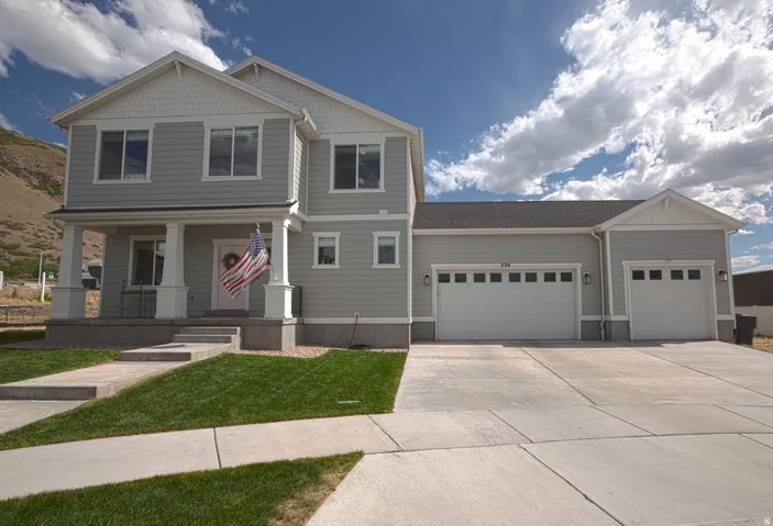 Two-story residence featuring light gray siding and white trim accents