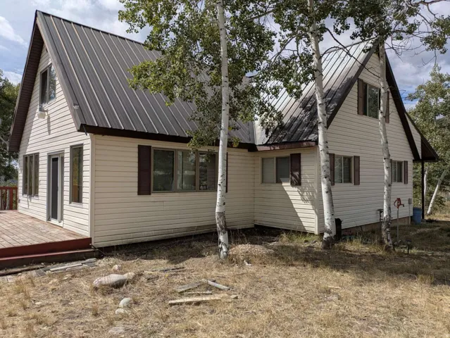 A-frame style residence featuring a brown metal roof and light-colored siding