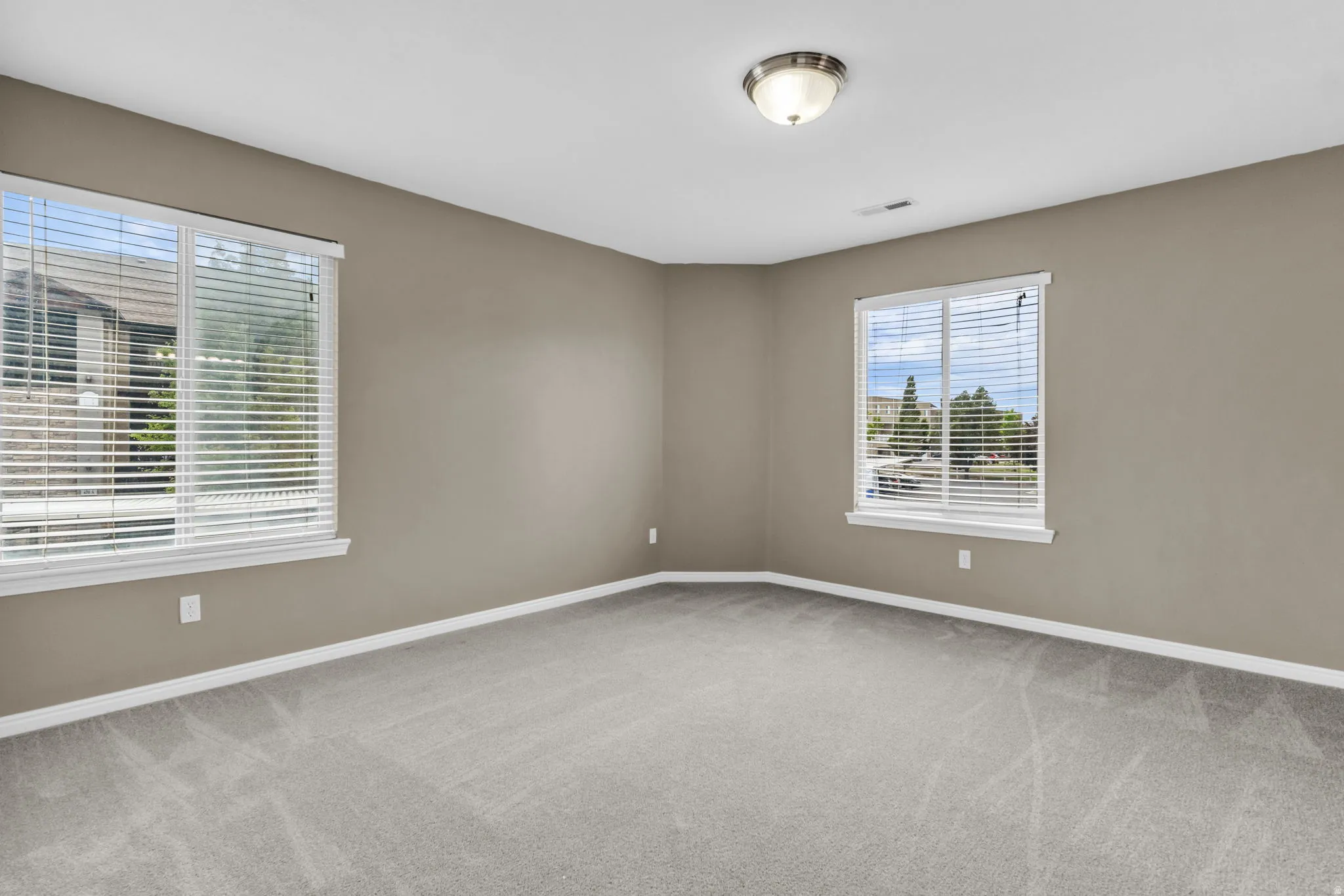 Carpeted room with neutral wall color and white trim.