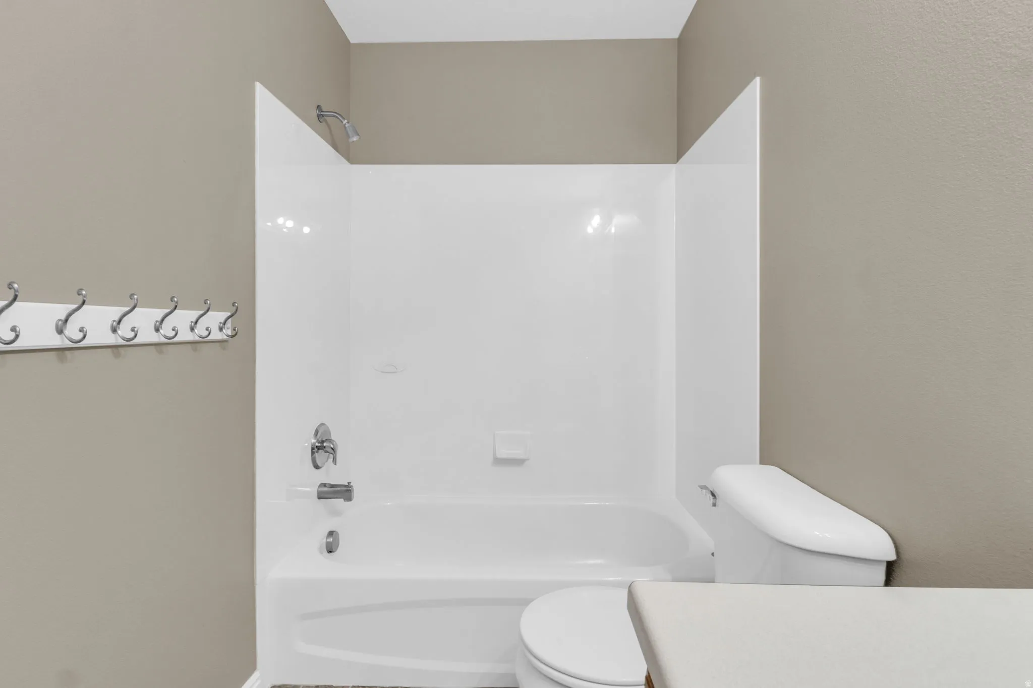 White bathtub and shower combination with chrome fixtures.