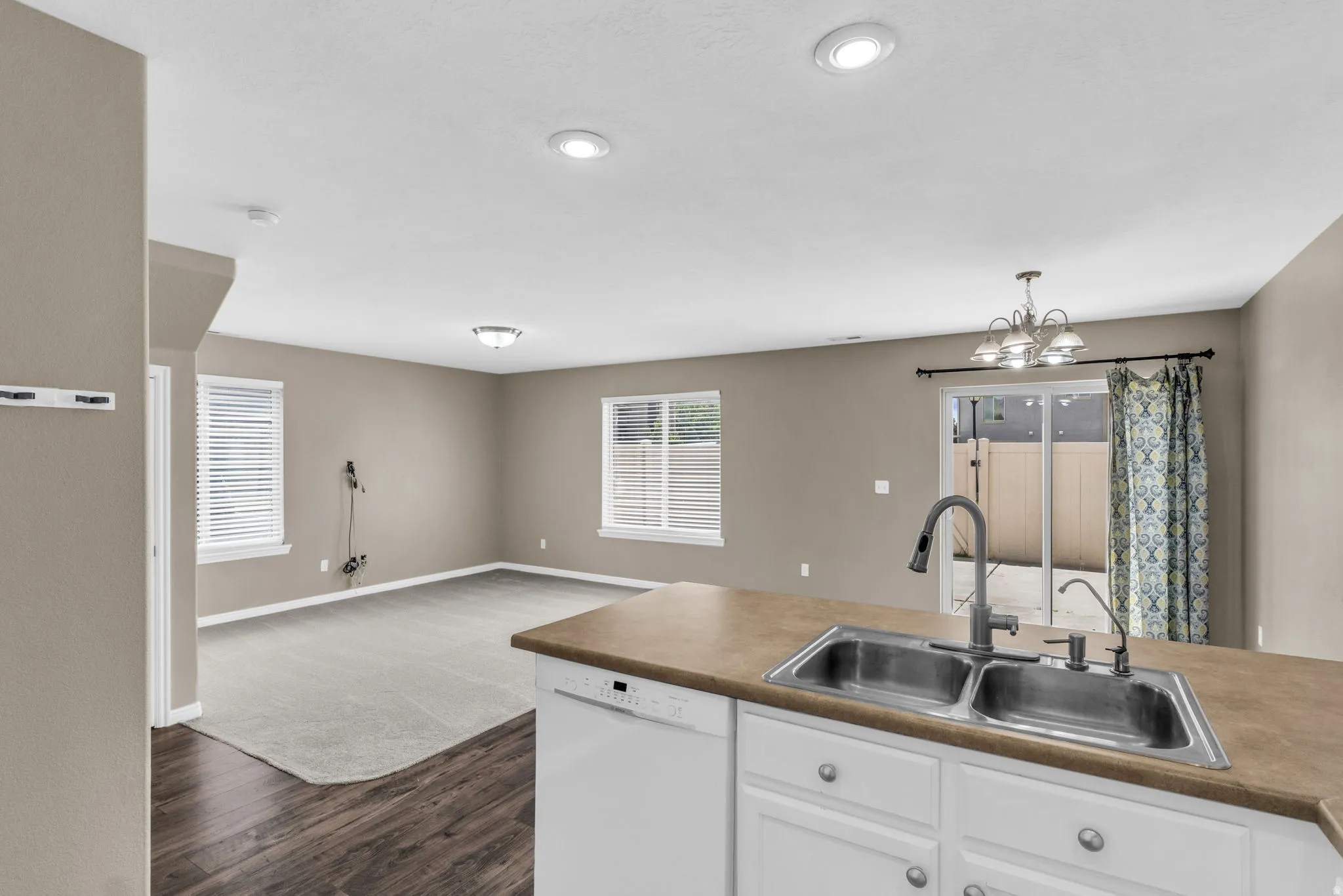 Kitchen island with a double basin stainless steel sink and a gooseneck faucet.